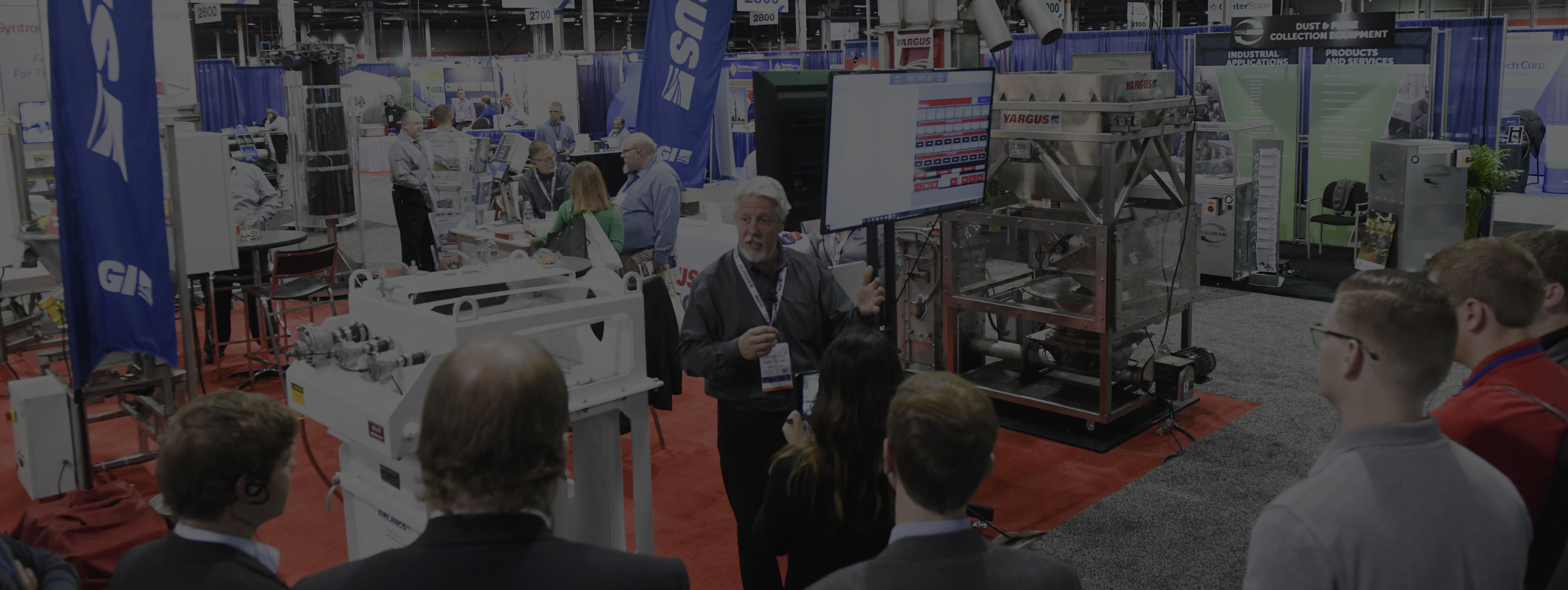 Exhibitor giving a demo of processing machines to expo hall crowd