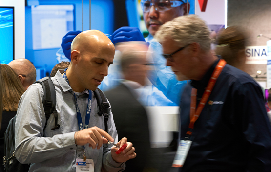 Two men examining a product in the expo hall floor